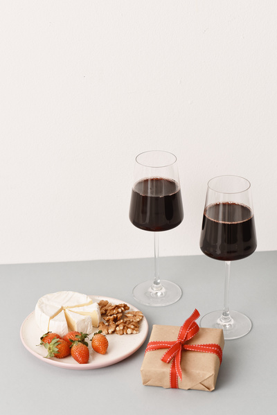 Flatley of Gift with Bow and Glasses of Wine with Snacks to It on Grey Background